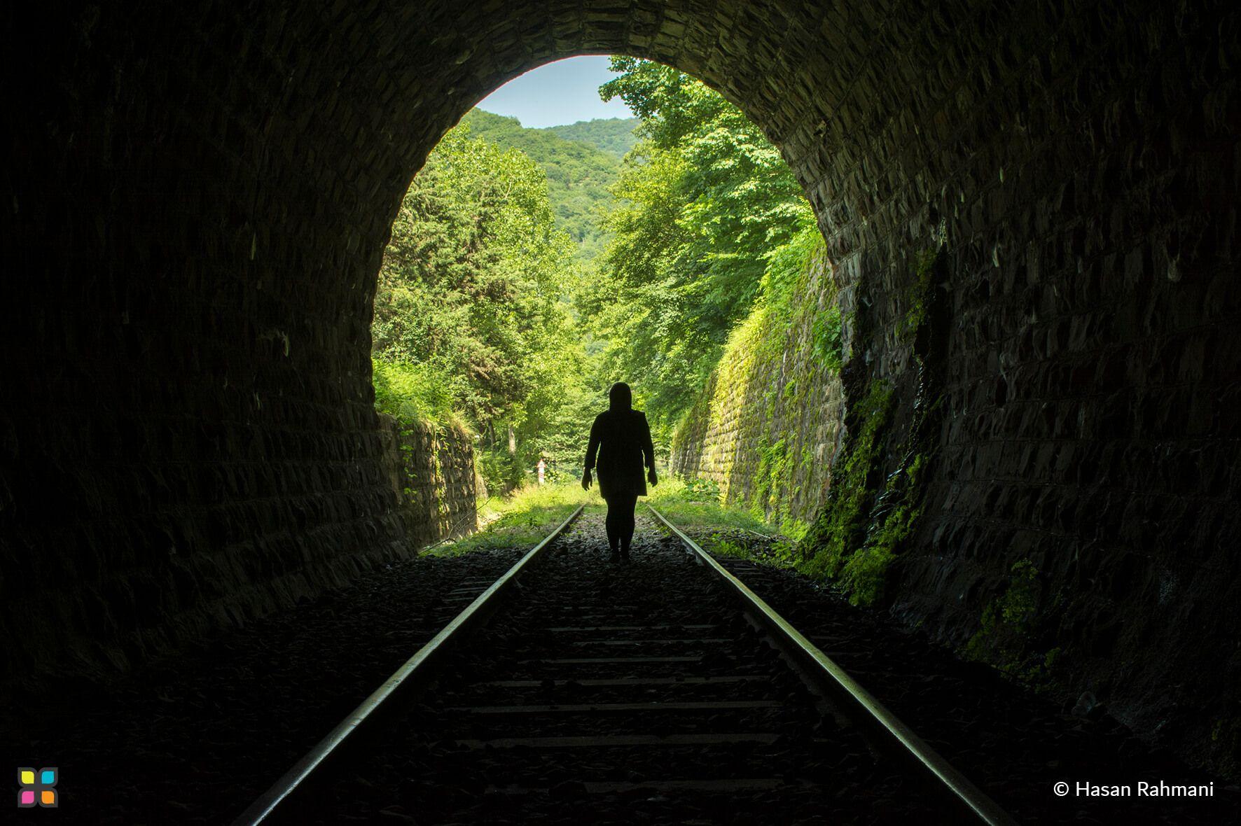 A woman emerges from a tunnel into a lush, forested landscape.
Photographer: Hasan Rahmani
Location: Iran