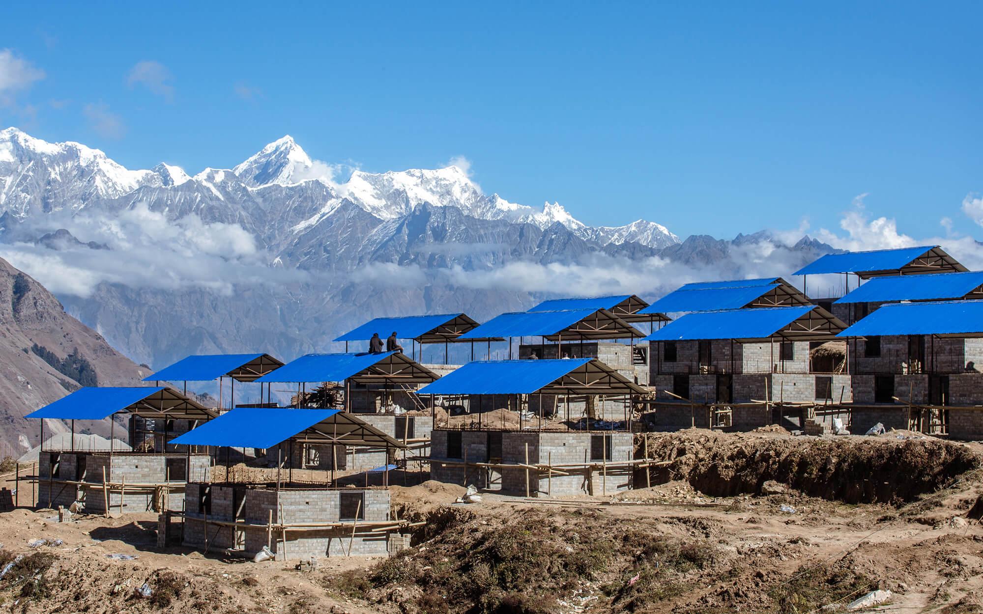 Houses under construction, with Nepal’s incredible mountain ranges behind them. 
Photographer: Rashik Maharjan
