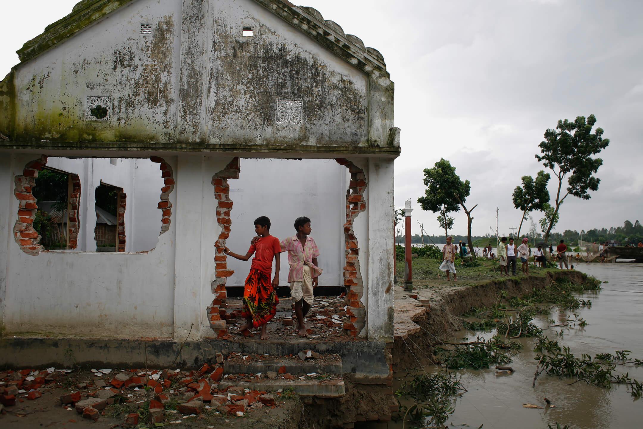 يقف تلميذان يافعان عند عتبة مبنى متصدّع بطل على مجرى نهر متعرّج. وقد أدّت الفيضانات وتآكل ضفاف الأنهار إلى إلحاق أضرار جسيمة بمئات المدارس في منطقة رايغزنج، سيراجغونج، فبات كثير من الأطفال محرومين من حقّهم في التعلّم.
اسم المصور: عبير عبدالله المكان: بنغلادش