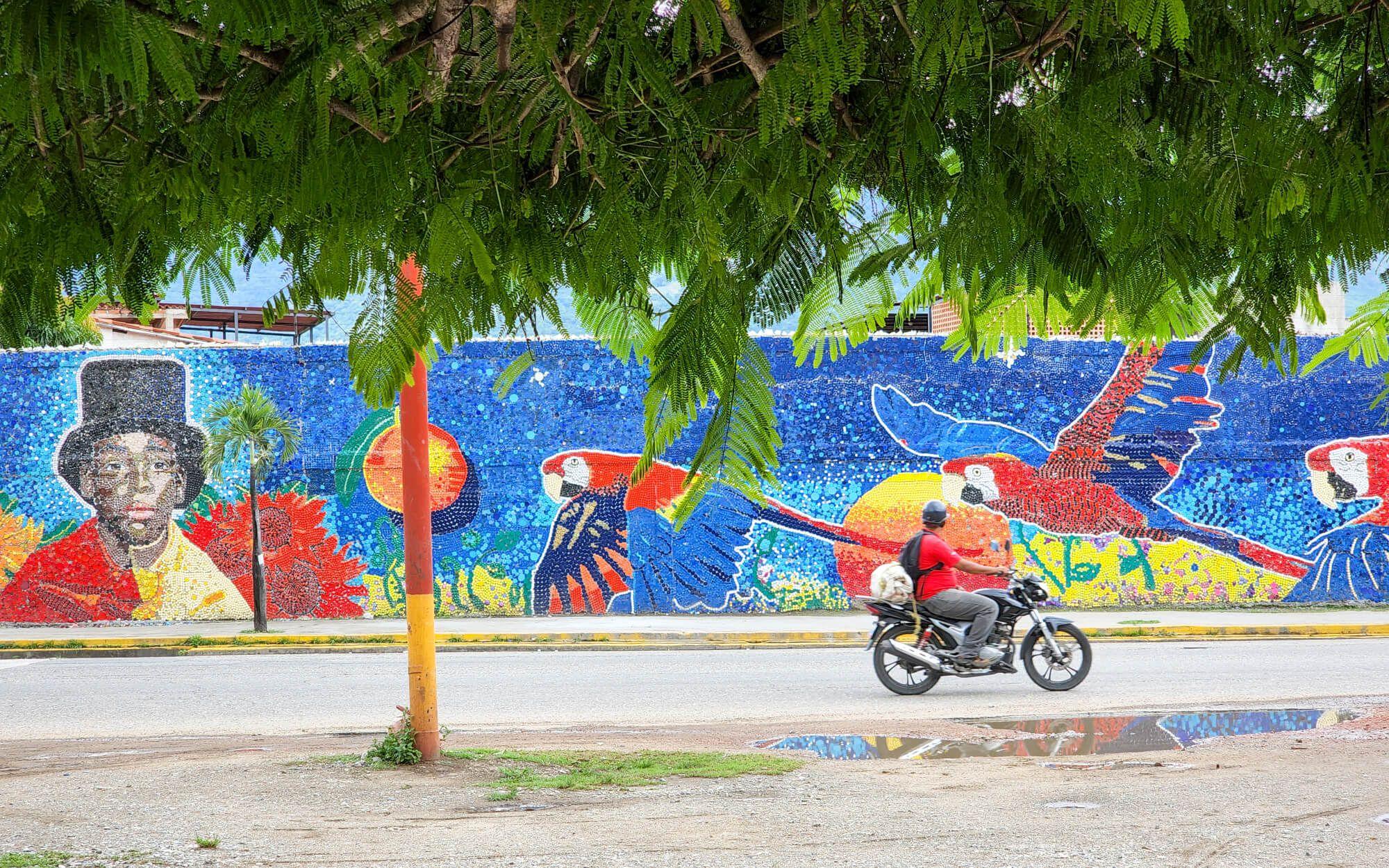 A local community member drives past an Oscar Olivares mural.
Photo: Oscar Olivares