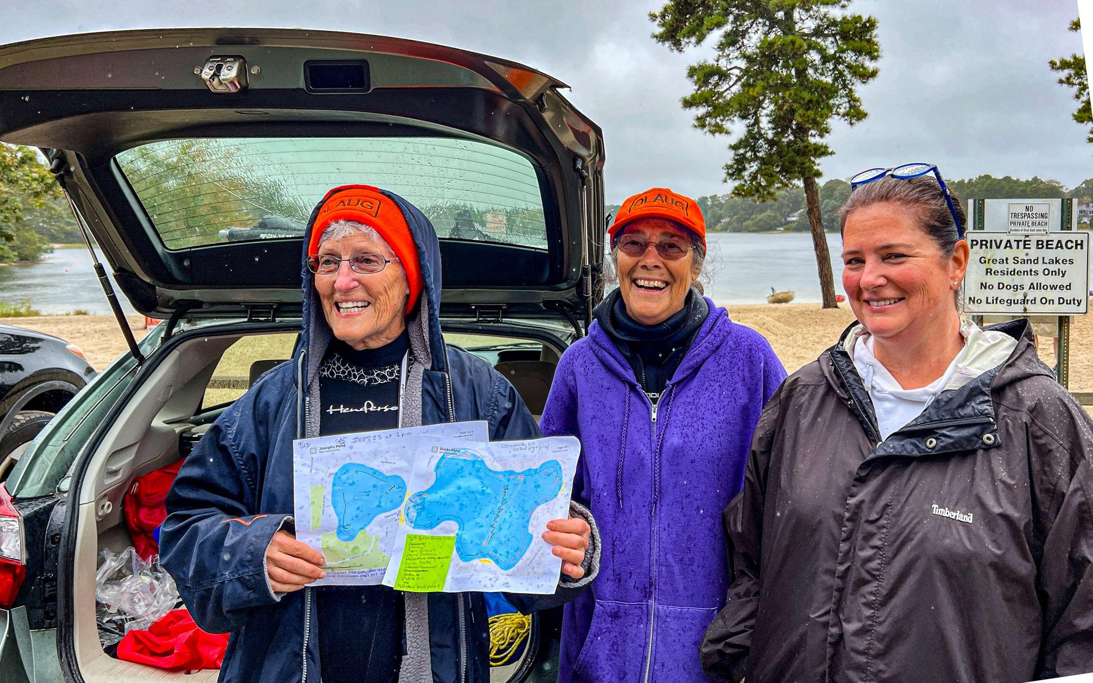 Members of OLAUG stand together, proudly displaying maps of the New England ponds they’re cleaning.
Photo: Old Ladies Against Underwater Garbage